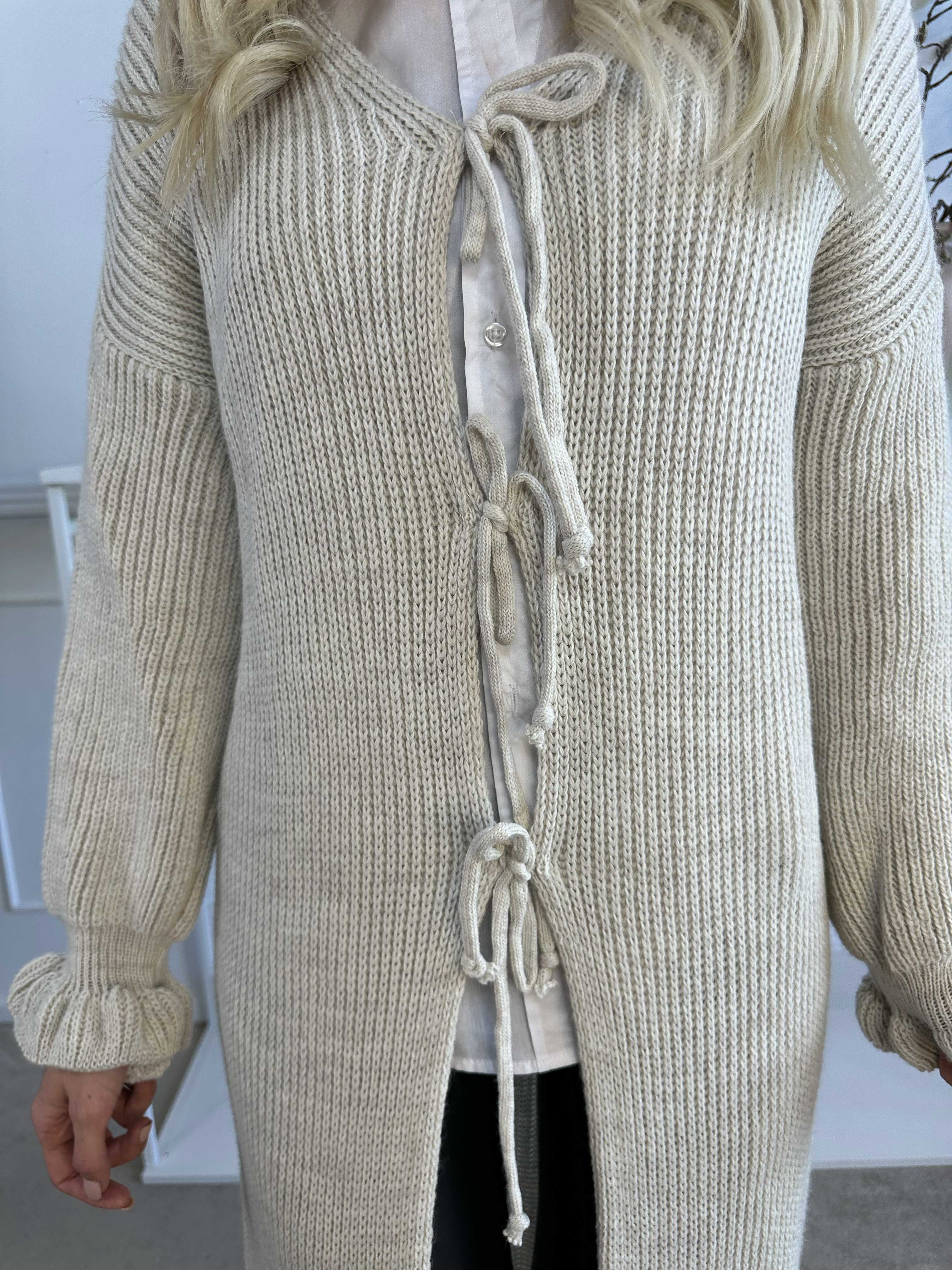 Catalina - Lång stickad kofta med rosetter och volangkant