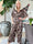 Pams Leafage Jumpsuit - Elastisk jumpsuit i lövmönster med guldfärgade tofsar