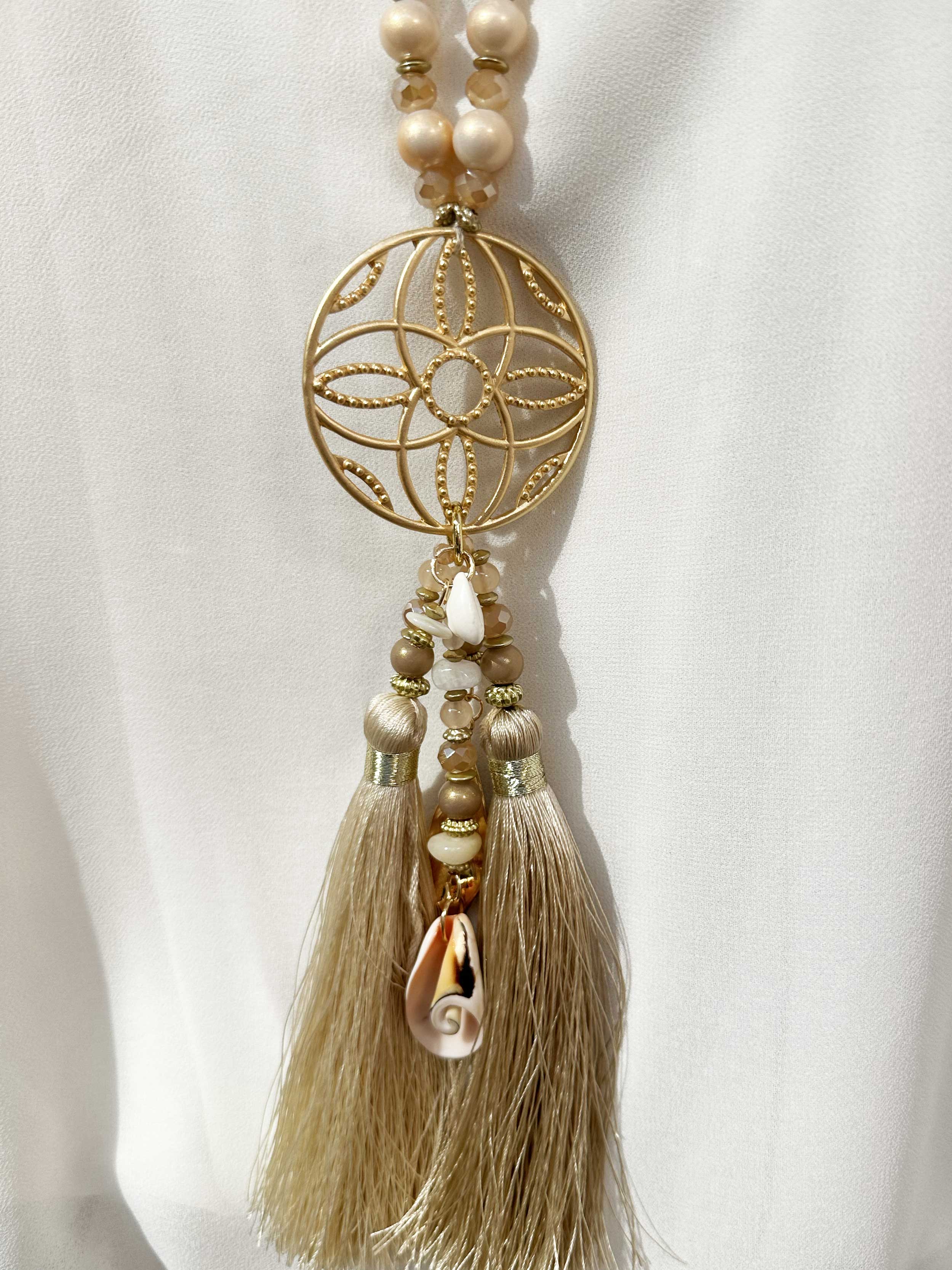 Lamia - Pärlhalsband med guldfärgat hänge och tofsar