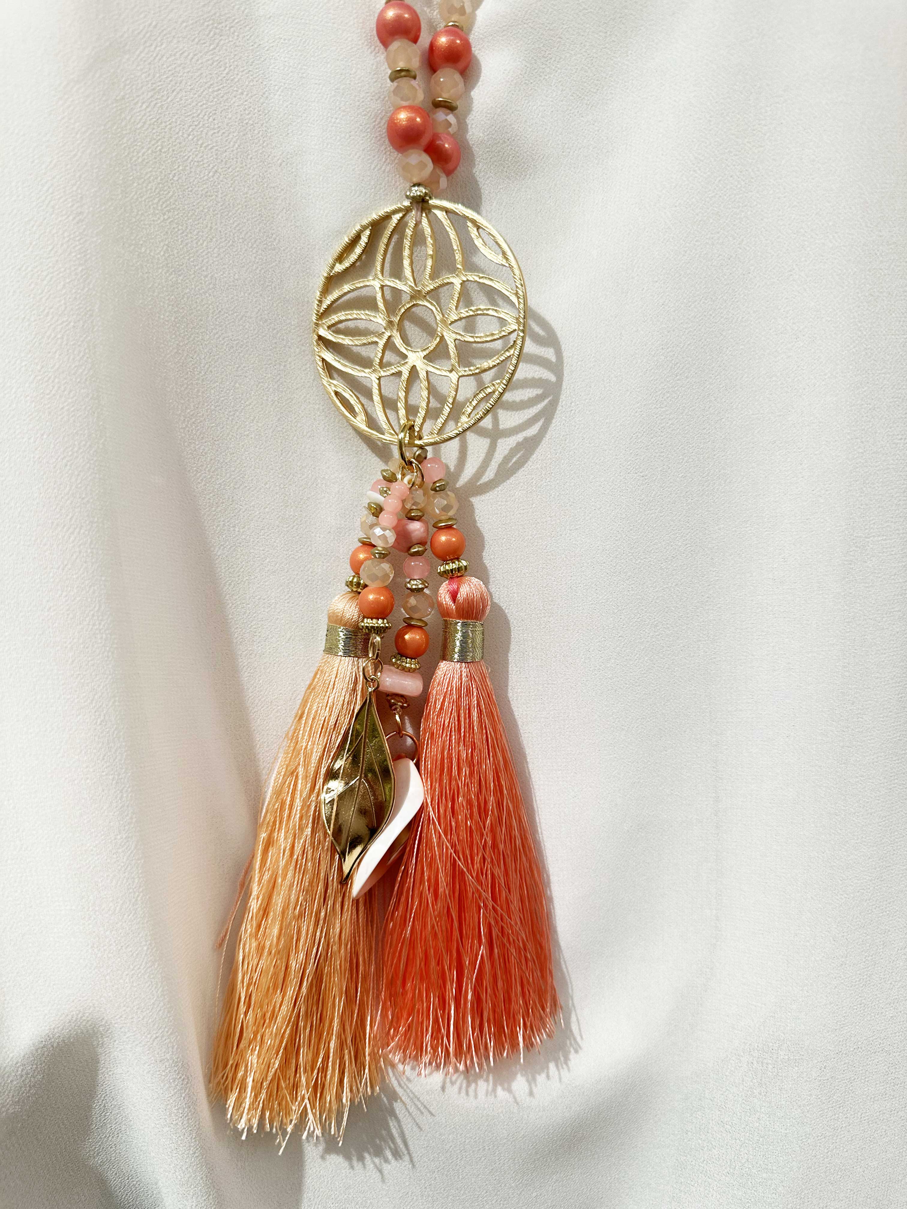 Lamia - Pärlhalsband med guldfärgat hänge och tofsar