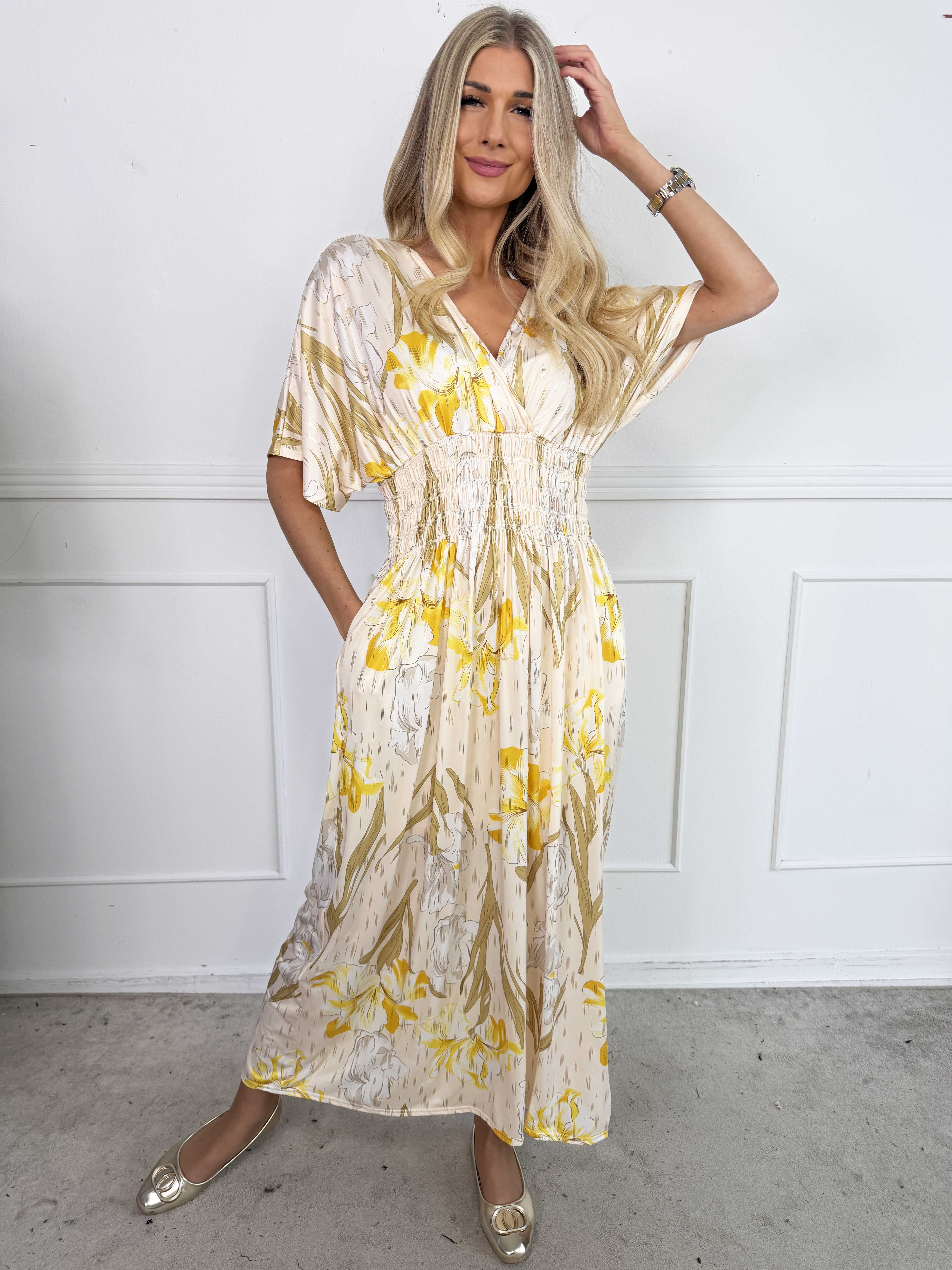 Pams Kvitka - Lång, stretchig blommig klänning med gulddetaljer och fickor