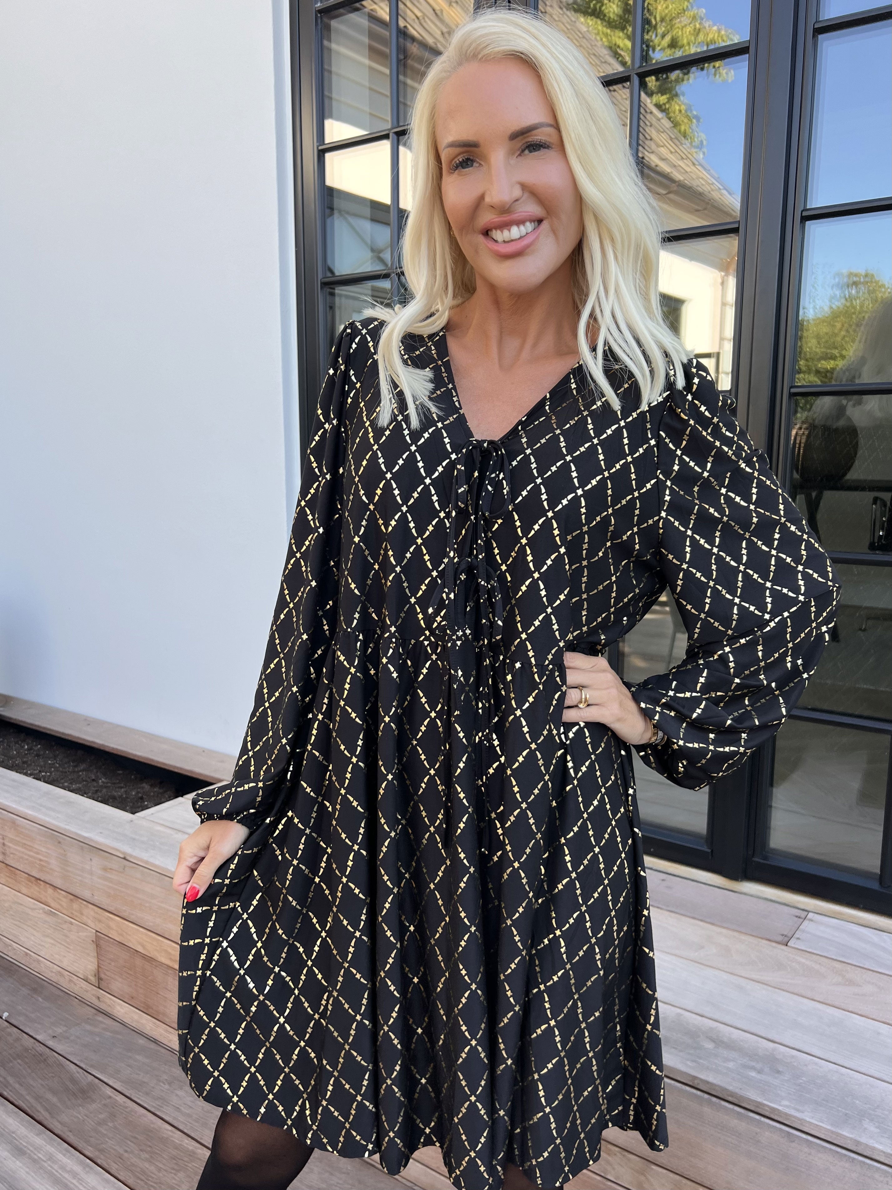 Cersei Gold Check - Babydoll klänning med guldfärgat mönster och rosetter