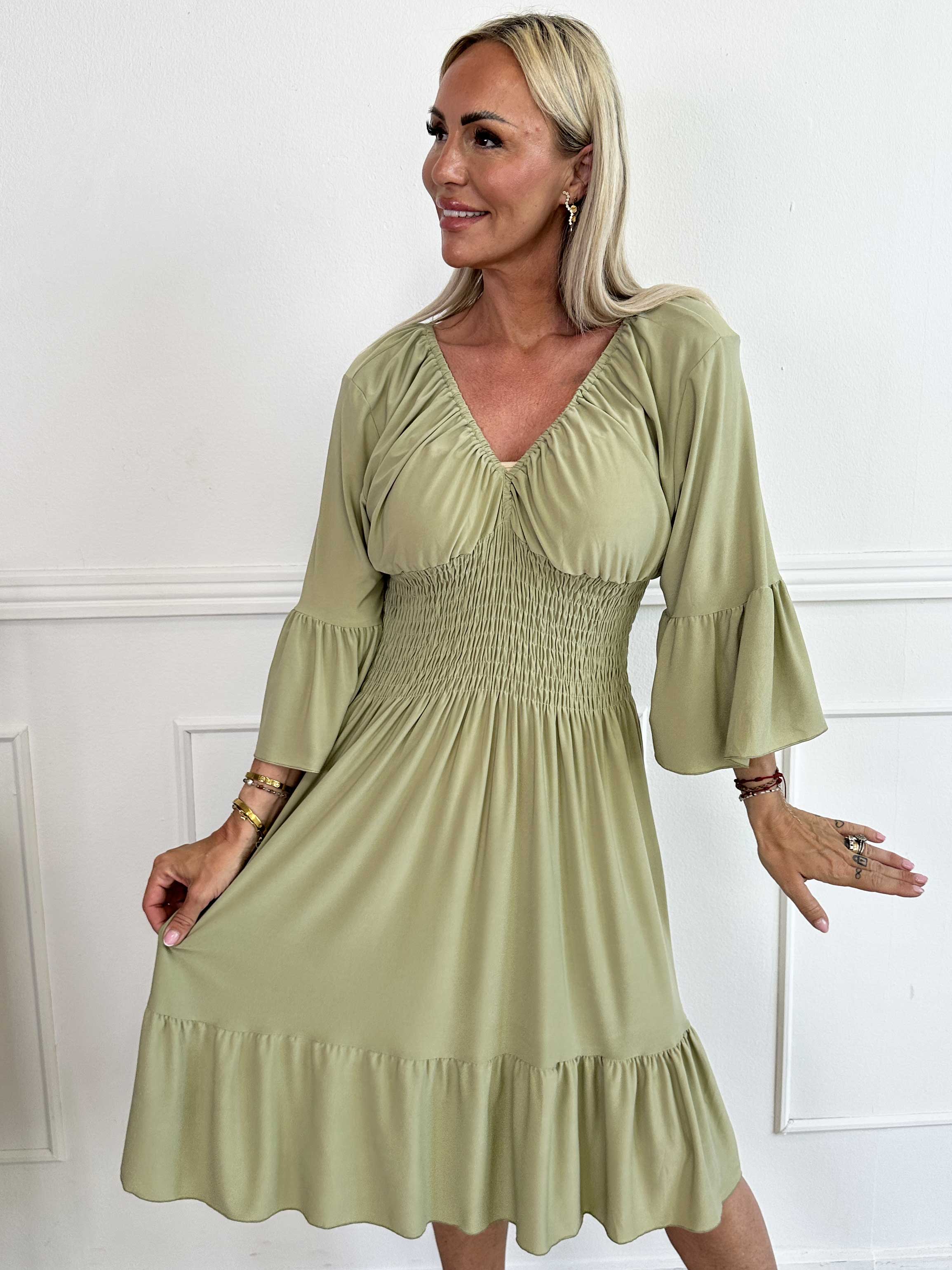 Flora Plain - Elastisk enfärgad klänning med resår och volang på ärmen