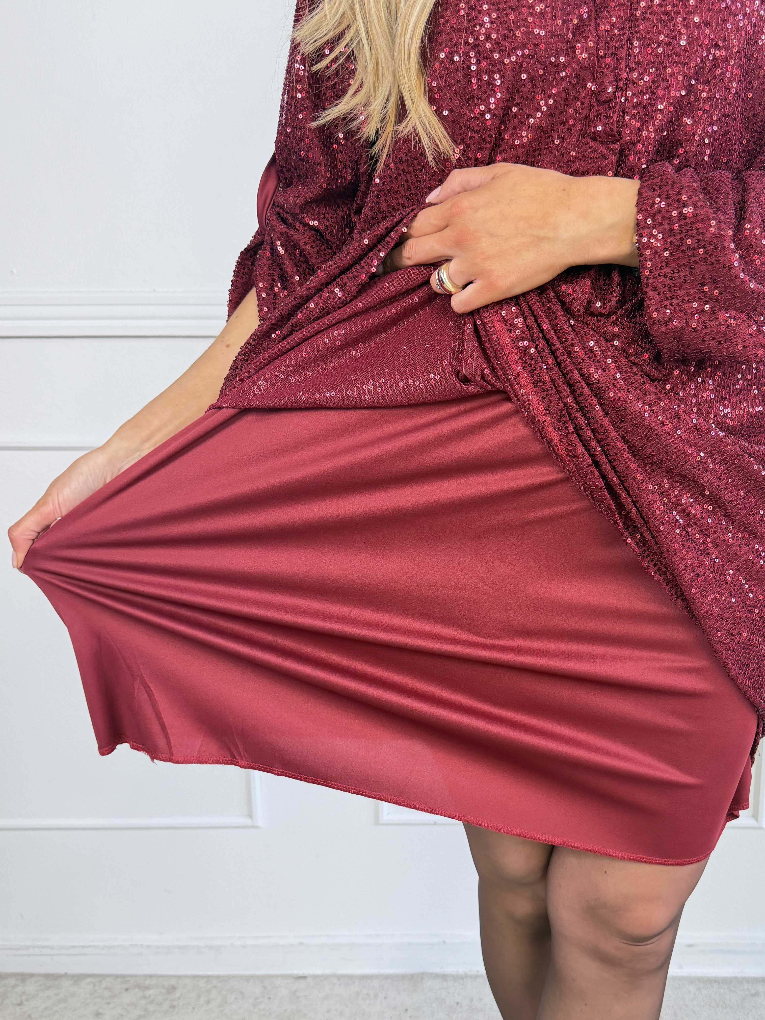 Ebba Glitter - Paljettklänning i plus size med knappar vid urringningen som ger en elegant look