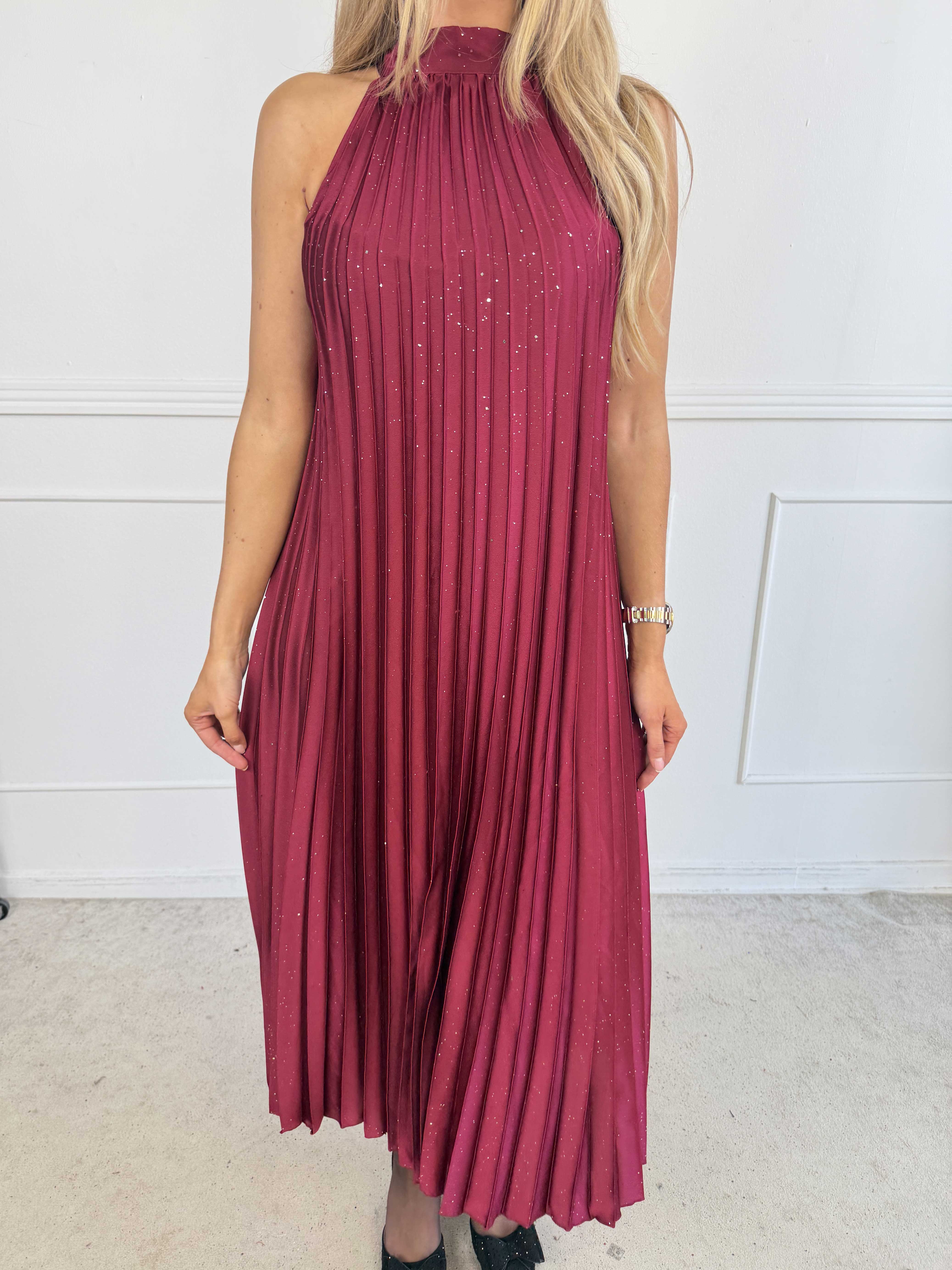 Madison Glitter - Lång plisserad klänning med fina glitterdetaljer, volangkant och en elegant rosett i nacken