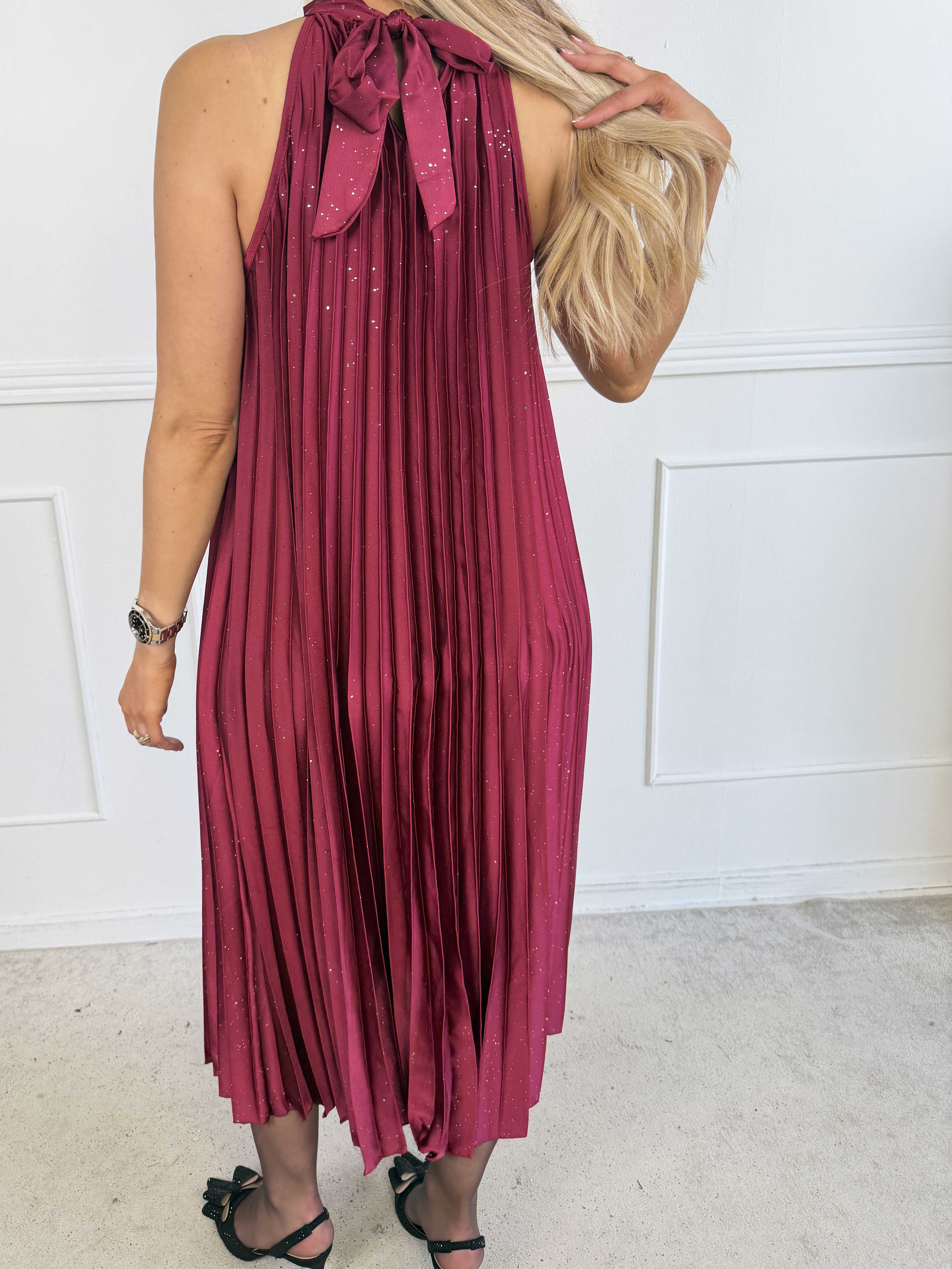 Madison Glitter - Lång plisserad klänning med fina glitterdetaljer, volangkant och en elegant rosett i nacken