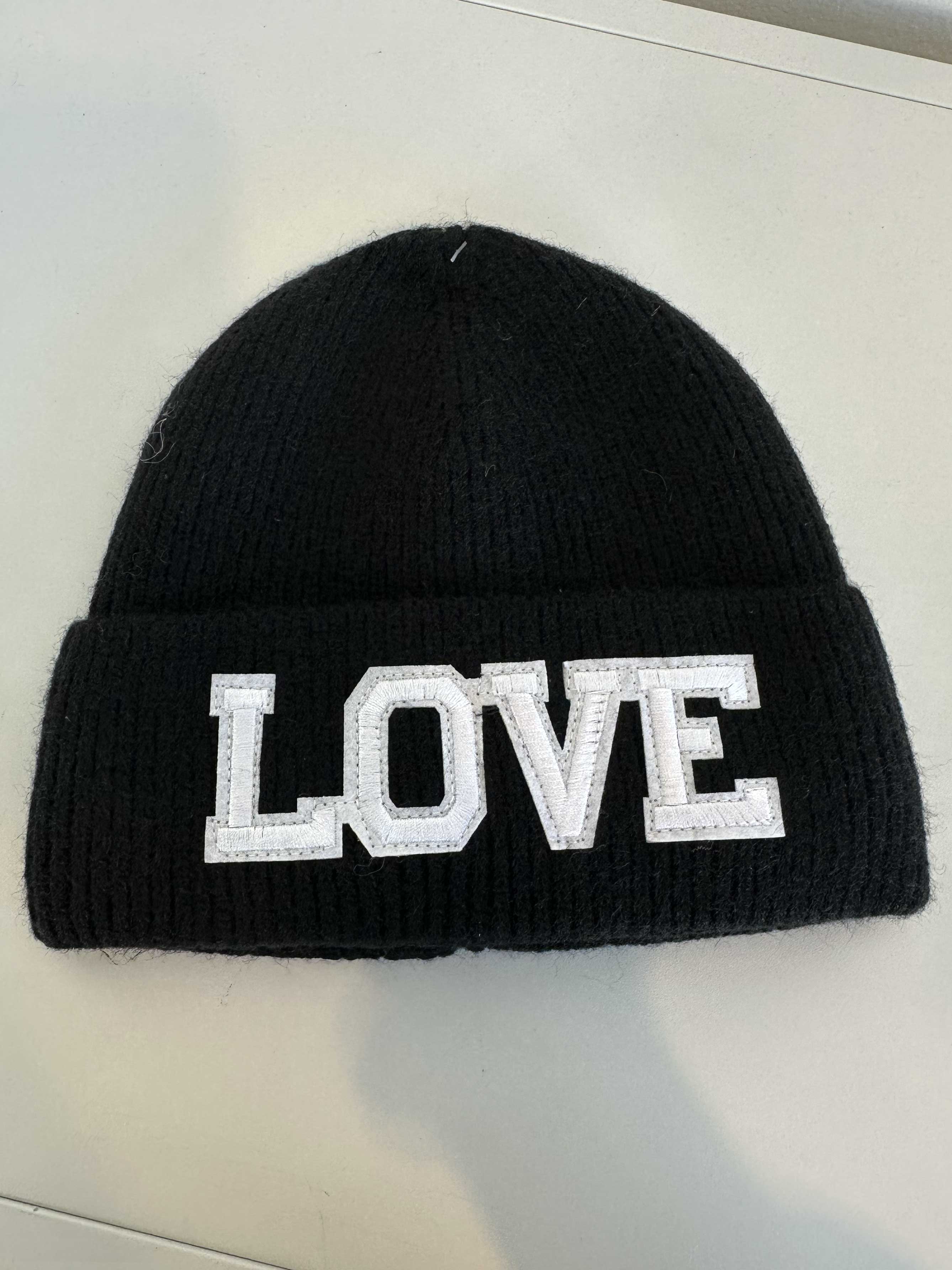 Neta - Stickad mössa med vit text