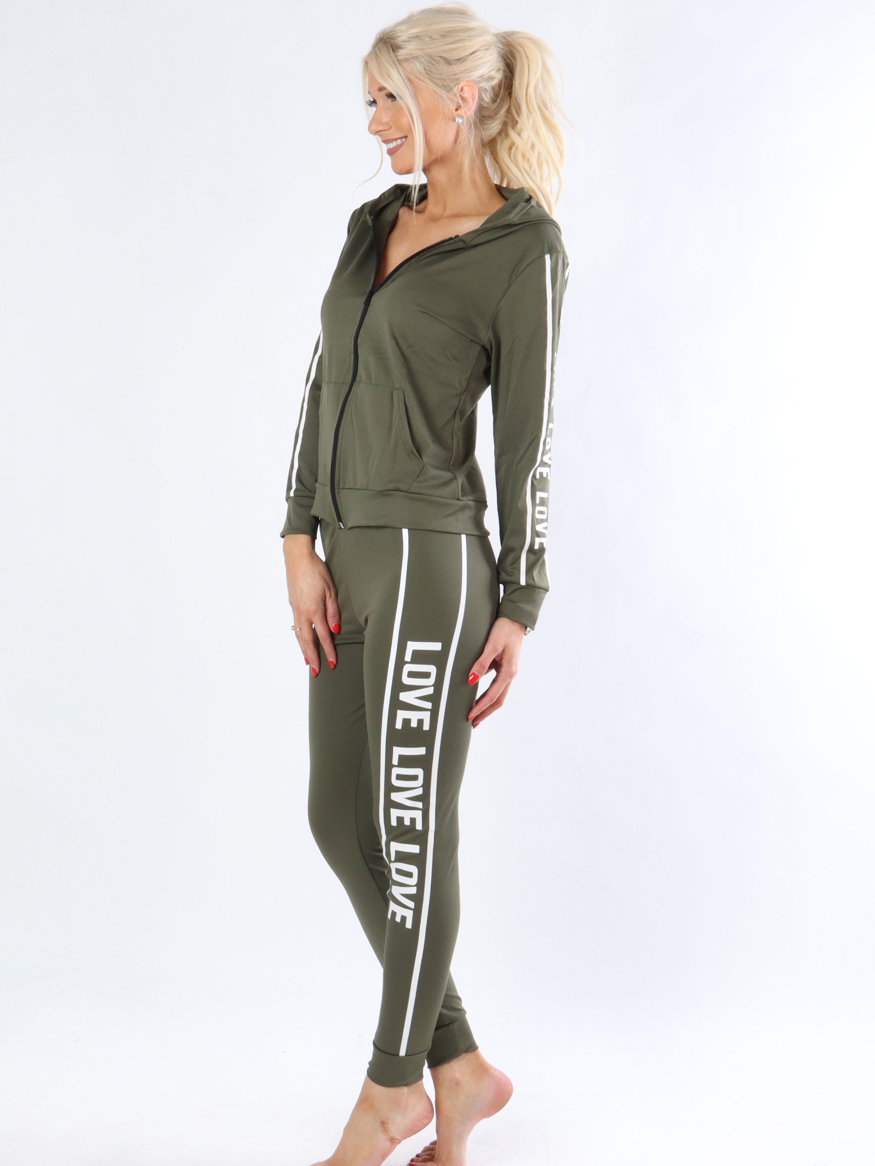 Juana - Armégrön joggingdräkt i elastiskt tyg med vit text.